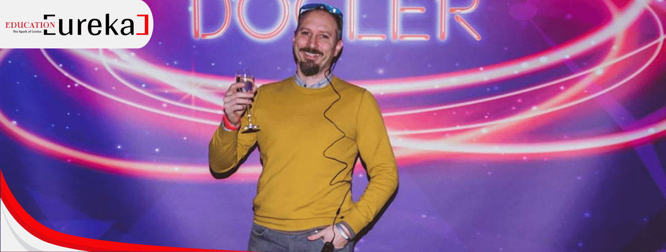 Federico Pizzutto at a tech event, holding a wine glass and smiling under vibrant lighting