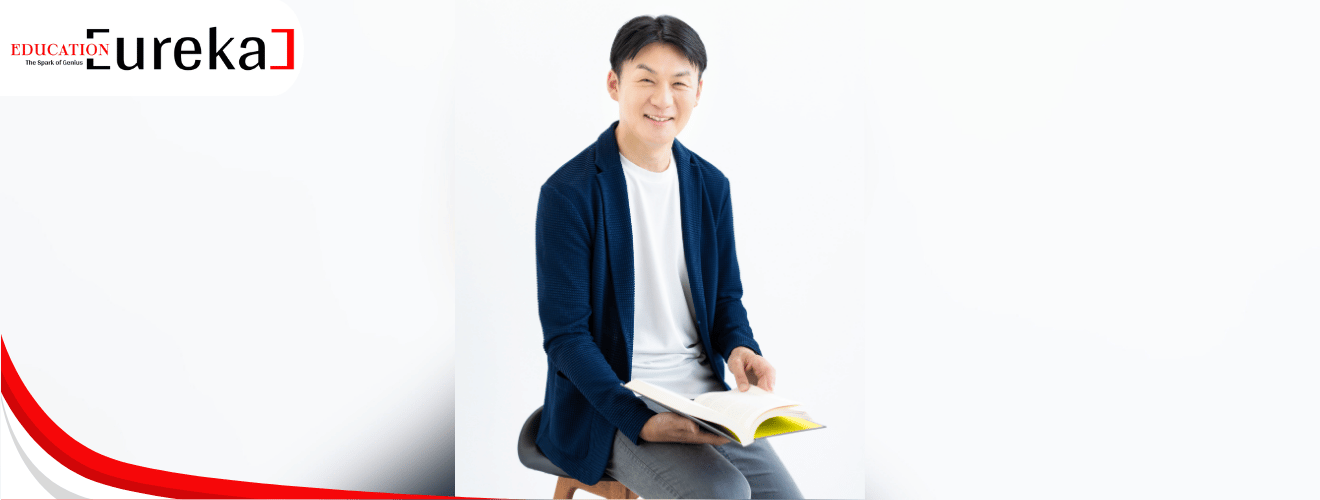 Kazuyoshi Hisano smiling while holding an open book