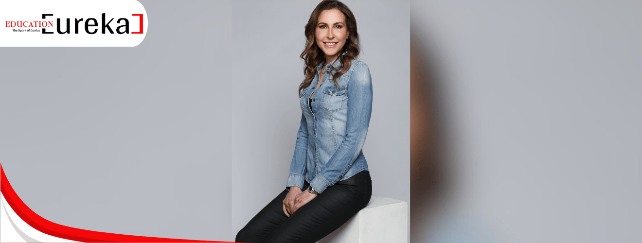 Teresa Greco seated gracefully in a denim shirt, smiling