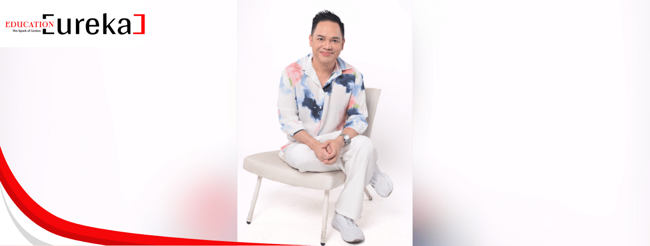 Motivational speaker Myke Celis seated in a modern chair, wearing a white outfit with a colorful shirt.
