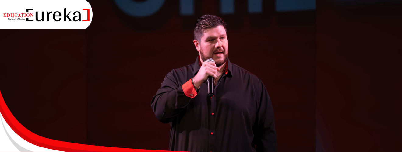 Tony Pec delivering a keynote speech on stage in front of a live audience